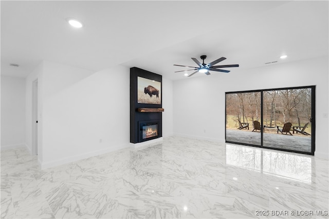 unfurnished living room with recessed lighting, marble finish floor, a fireplace, and baseboards