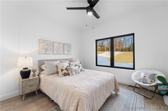 bedroom featuring visible vents, a ceiling fan, baseboards, and wood finished floors