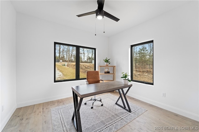 office area featuring baseboards, a ceiling fan, and light wood finished floors