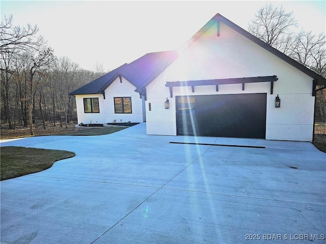 view of front of home featuring stucco siding, a garage, and concrete driveway