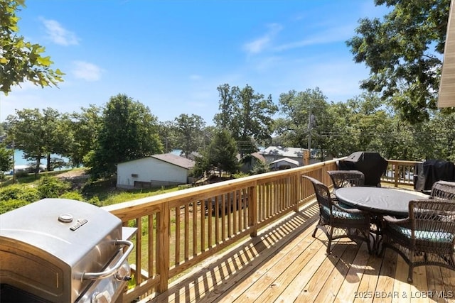 wooden deck featuring a grill and outdoor dining space