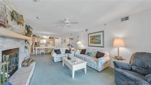 living area with light carpet, a stone fireplace, a textured ceiling, and visible vents