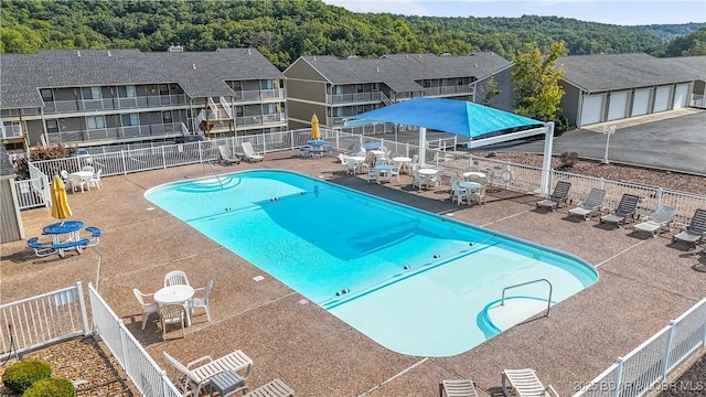 community pool with fence and a patio