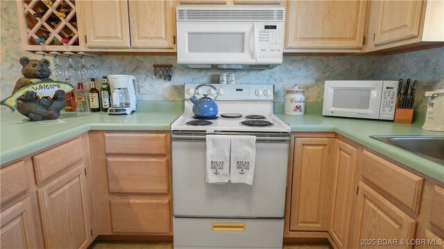 kitchen with white appliances, light countertops, backsplash, and light brown cabinets