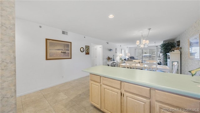 kitchen featuring a notable chandelier, light countertops, visible vents, light brown cabinetry, and open floor plan