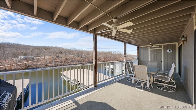 balcony with outdoor dining area and ceiling fan