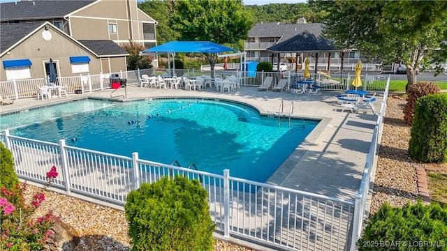 community pool with a patio area and fence