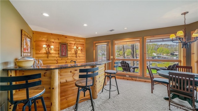 bar featuring visible vents, log walls, a wealth of natural light, and recessed lighting