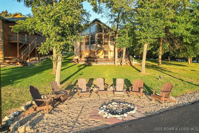 view of yard with stairs, a fire pit, a patio, and a wooden deck