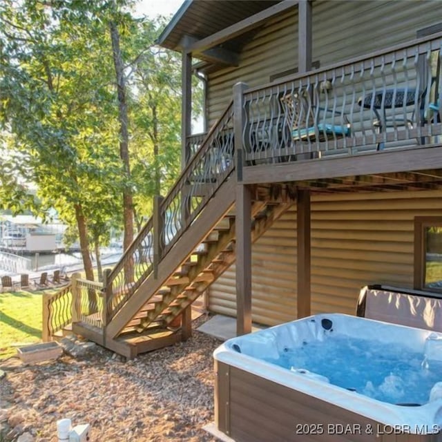 exterior space featuring stairs, a wooden deck, and a hot tub