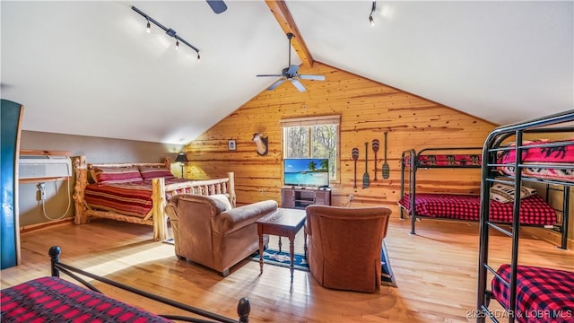 bedroom with vaulted ceiling with beams, wood walls, wood-type flooring, and a wall mounted air conditioner