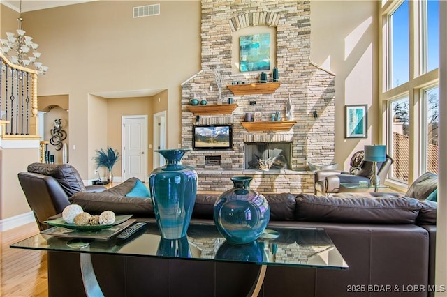 260 Greystone Ln, Villages, MO 65079 - living area with a stone fireplace, wood finished floors, a towering ceiling, visible vents, and baseboards