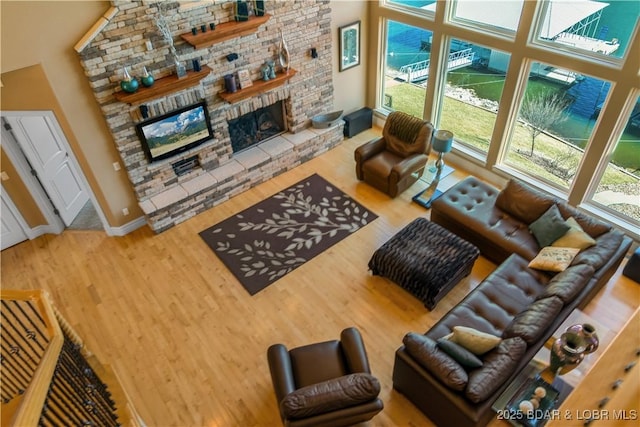 260 Greystone Ln, Villages, MO 65079 - living area featuring a large fireplace, a high ceiling, baseboards, and wood finished floors