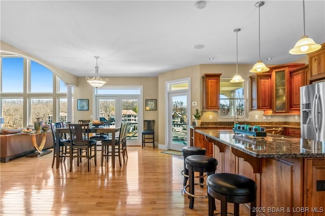 260 Greystone Ln, Villages, MO 65079 - kitchen with ornate columns, stainless steel fridge, and brown cabinetry
