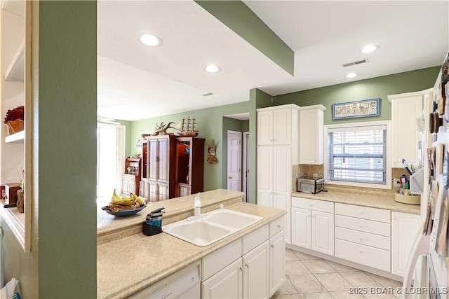 kitchen with light tile patterned floors, white dishwasher, recessed lighting, a sink, and light countertops