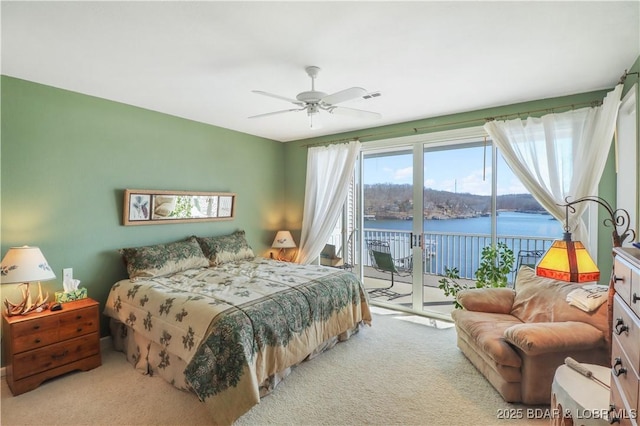 bedroom with access to exterior, carpet flooring, a water view, and visible vents