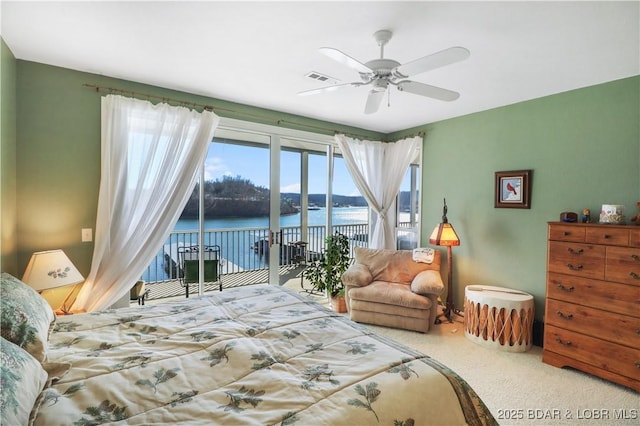 bedroom with a water view, carpet flooring, visible vents, a ceiling fan, and access to outside