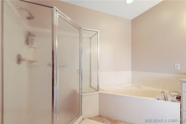 full bath featuring a stall shower and a garden tub