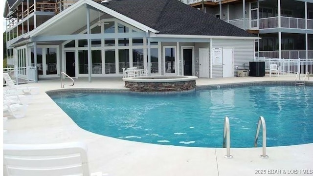 community pool featuring a community hot tub, a patio area, and fence