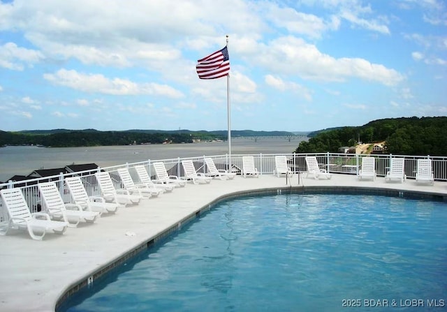 community pool with a patio area and fence