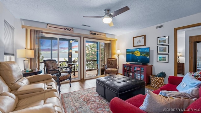 living room featuring a textured ceiling, wood finished floors, and visible vents