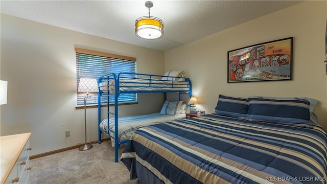 bedroom with a textured ceiling, carpet, and baseboards