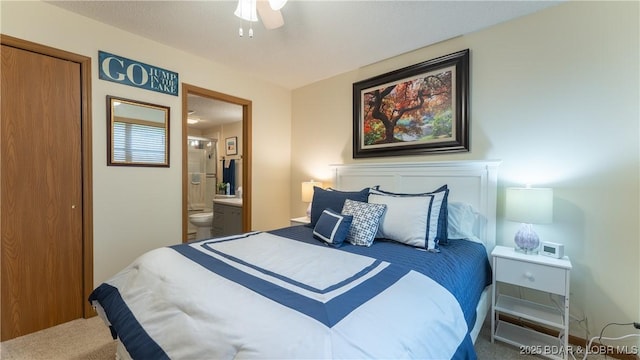 carpeted bedroom featuring ensuite bath and a ceiling fan