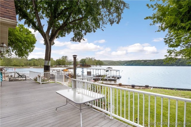 wooden terrace with a water view, a lawn, and a boat dock