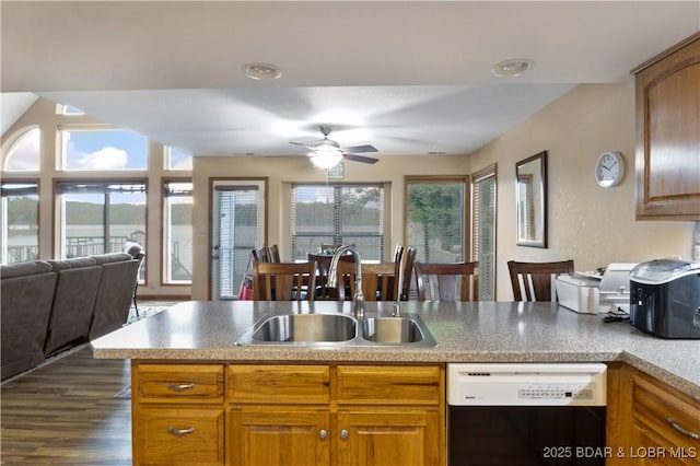 kitchen with a peninsula, dark wood-style flooring, a sink, open floor plan, and dishwasher