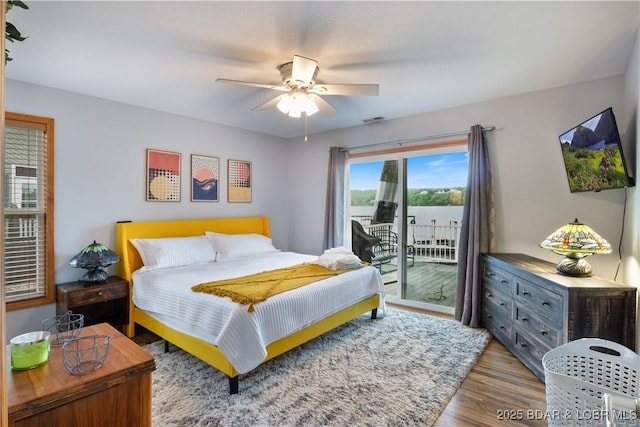 bedroom featuring access to exterior, a ceiling fan, and wood finished floors