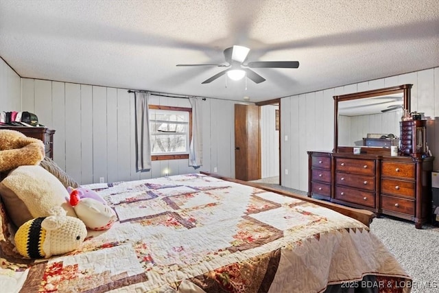 bedroom featuring a textured ceiling, carpet floors, and a ceiling fan