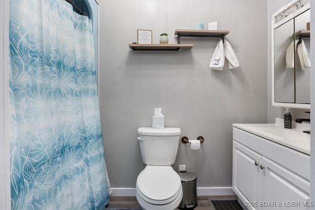 full bathroom featuring baseboards, vanity, toilet, and wood finished floors