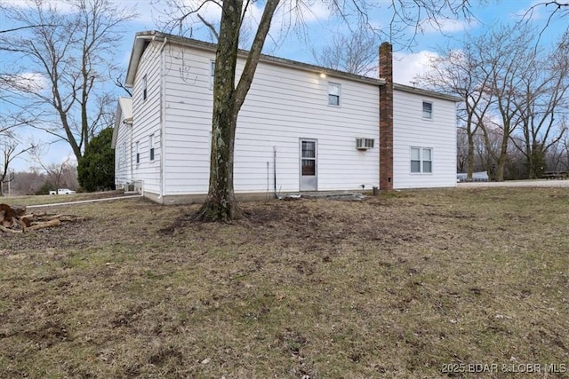 back of house with a chimney and a wall mounted AC