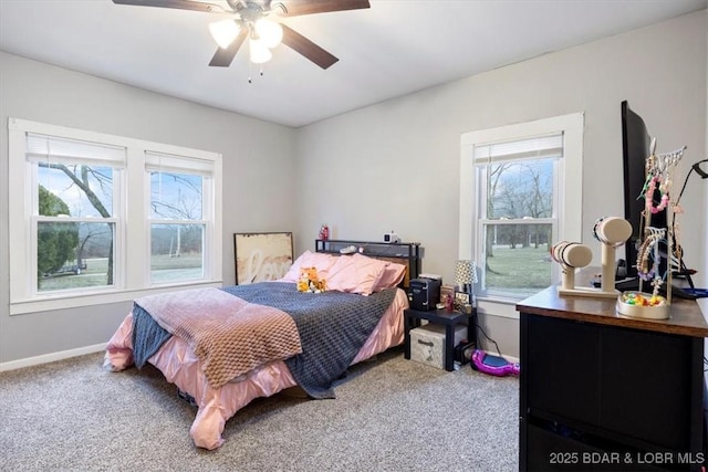 carpeted bedroom with ceiling fan, multiple windows, and baseboards