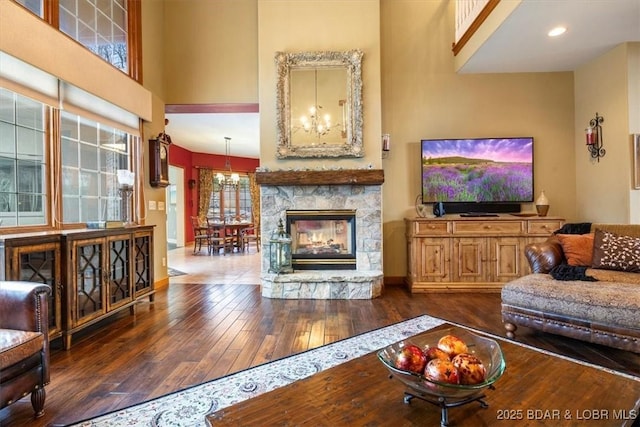 living room with an inviting chandelier, a high ceiling, and hardwood / wood-style flooring