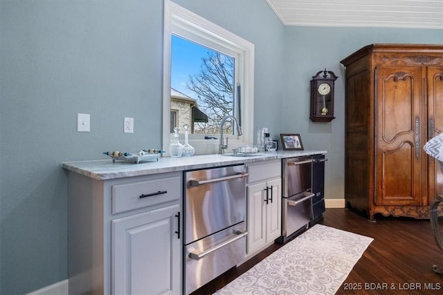 bar with dishwasher, dark wood finished floors, baseboards, and a sink