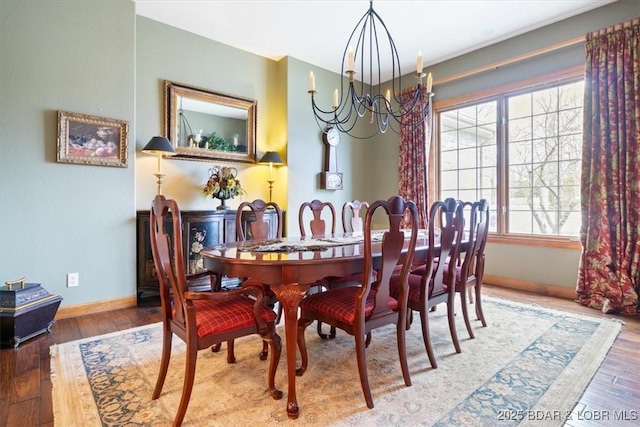 dining room featuring a chandelier, baseboards, and hardwood / wood-style flooring