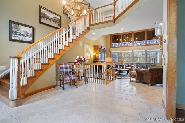 stairway featuring recessed lighting, a notable chandelier, a high ceiling, baseboards, and tile patterned floors