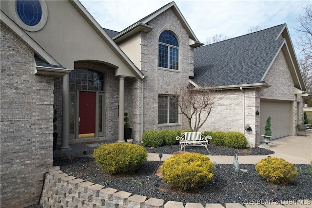 view of front facade featuring a shingled roof, brick siding, driveway, and a garage