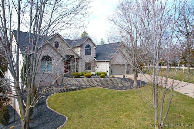 view of front of property with a front yard, concrete driveway, and an attached garage