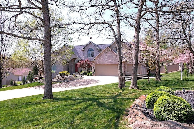traditional-style house featuring driveway, a front lawn, and an attached garage
