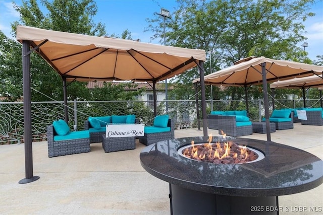 view of patio featuring an outdoor living space with a fire pit, fence, and a gazebo