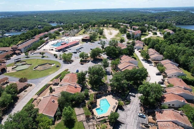 aerial view featuring a residential view, a water view, and a view of trees