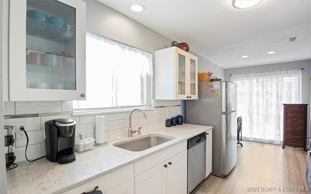 71 Costa Del Sol Dr Unit 207, Lake Ozark, MO 65049 - kitchen with tasteful backsplash, glass insert cabinets, white cabinets, stainless steel appliances, and a sink