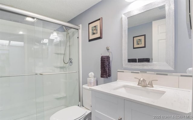 71 Costa Del Sol Dr Unit 207, Lake Ozark, MO 65049 - bathroom featuring visible vents, toilet, a textured ceiling, vanity, and a stall shower