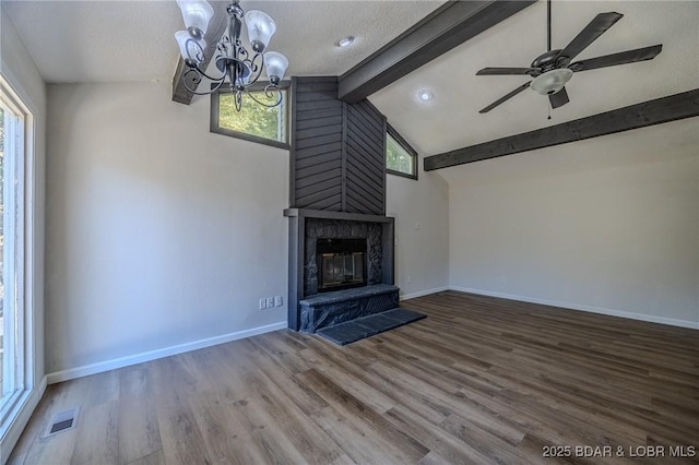 unfurnished living room featuring lofted ceiling with beams, a fireplace, wood finished floors, visible vents, and baseboards