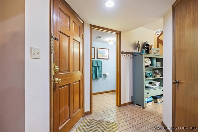 corridor with light tile patterned flooring, visible vents, and baseboards