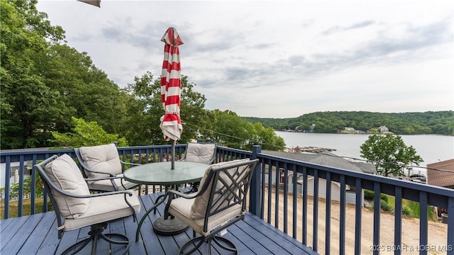 wooden deck with outdoor dining area and a water view