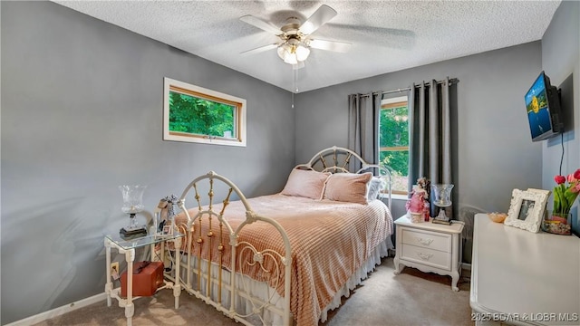 bedroom featuring a textured ceiling, carpet flooring, a ceiling fan, and baseboards