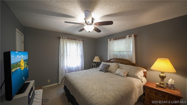 carpeted bedroom with a ceiling fan, a textured ceiling, and baseboards